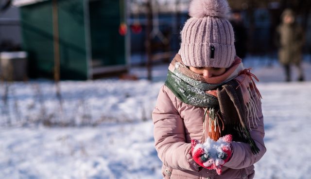 A child wear pink down jacket playing the snow, enjoy the winner